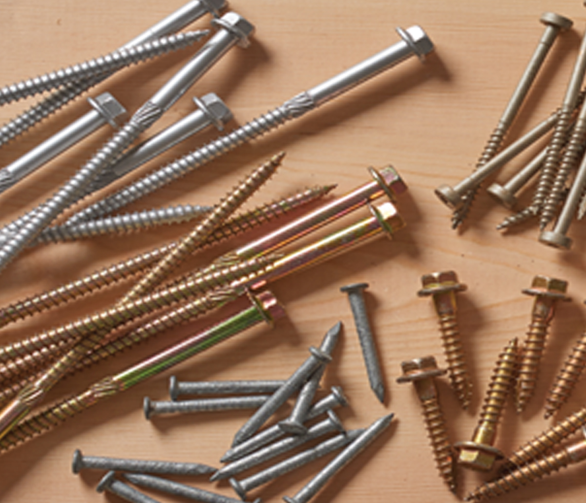 MiTek Fasteners Engineered Systems Products - A number of hex-head screws lying on a board