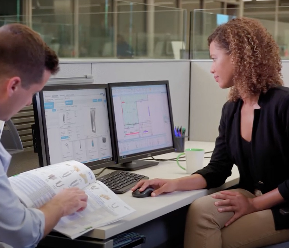 MiTek Project Management Services - Man and woman sitting at desk working at a computer