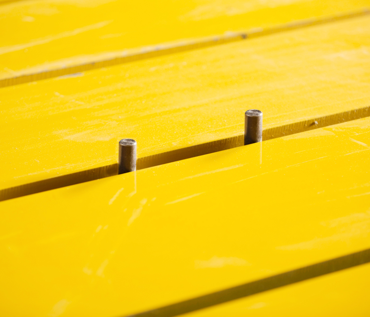 MiTek Wizard PDS Automated Solutions - Two metal pegs sticking up between two yellow boards